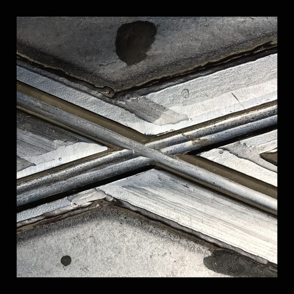 Two metal rails crossing over a concrete surface