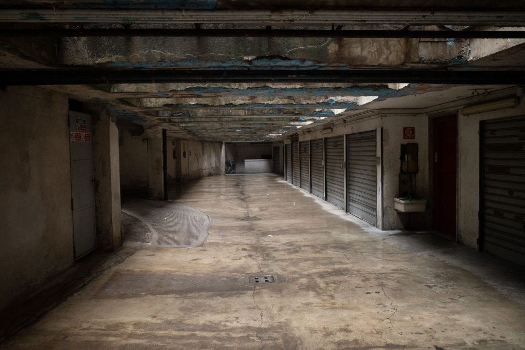 Long dark garage corridor with a beamed ceiling receding in perspective