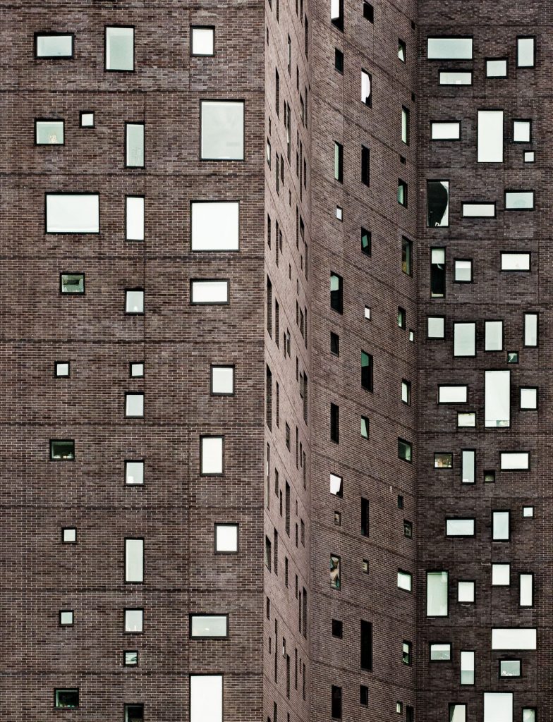 Brown facade with square and rectangular windows arranged irregularly