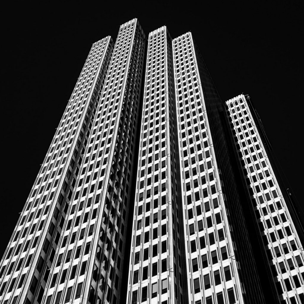 Black and white skyscrapers converging upward against a black sky