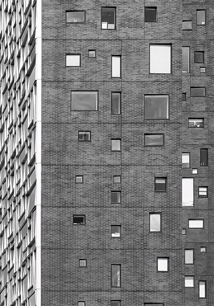 Black and white facade articulated by windows of irregular sizes