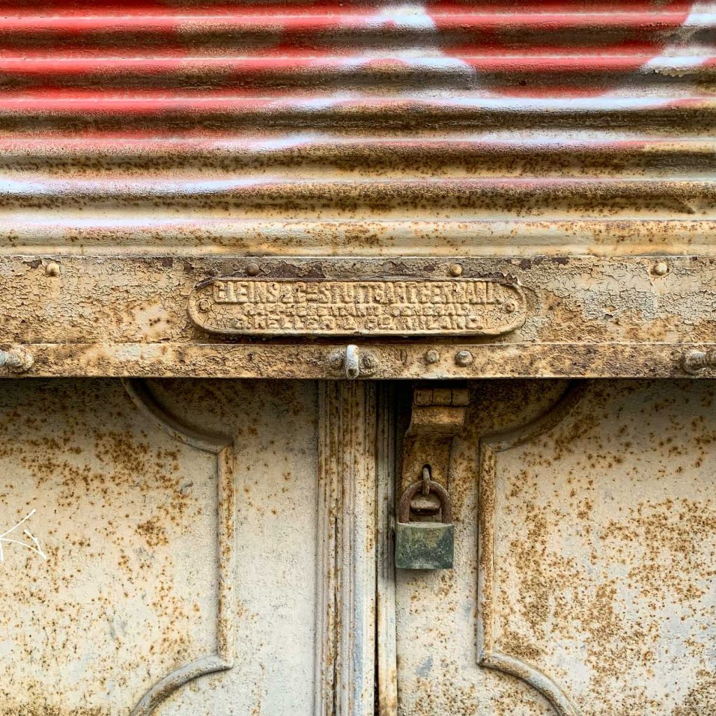 Rusted metal shutter with a maker's plate at its centre