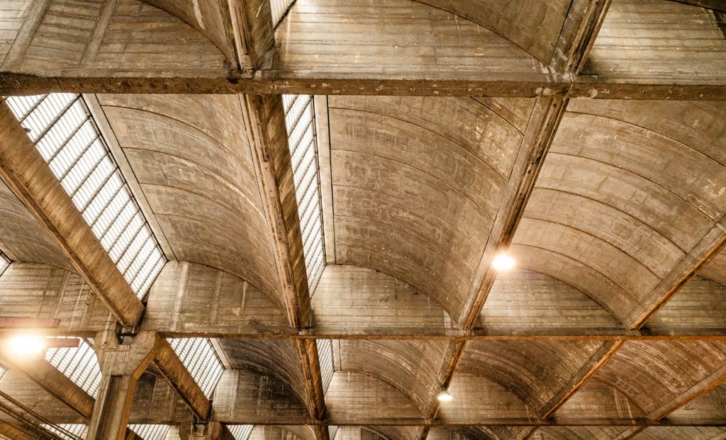 Industrial roof of metal trusses with skylights and hanging lamps