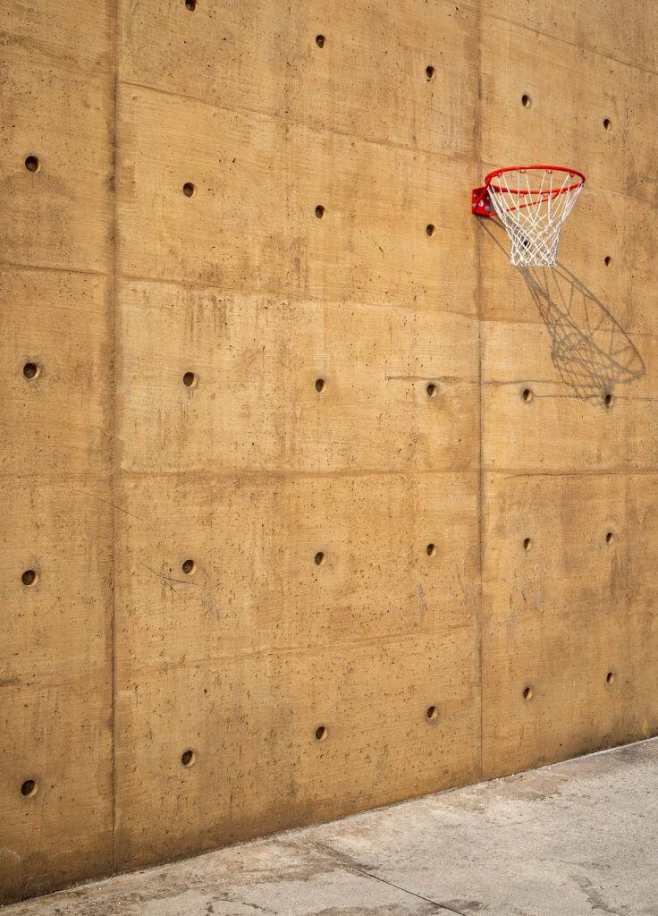 Concrete wall with a basketball hoop mounted on it