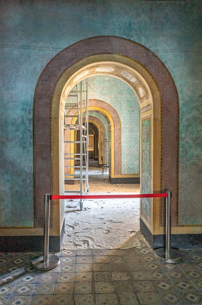 Row of arches painted pale blue, with red barrier tape in the foreground