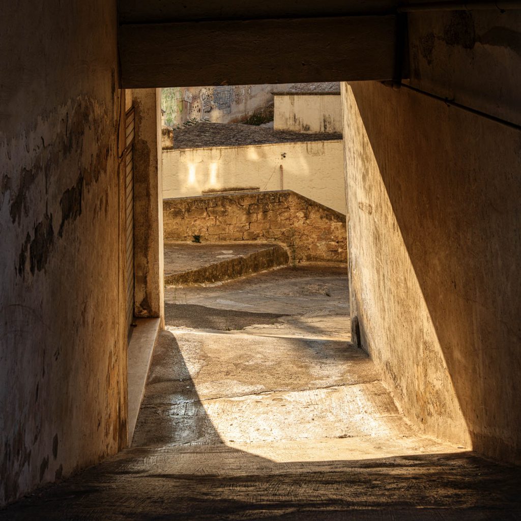 Concrete underpass with light entering through an angled opening