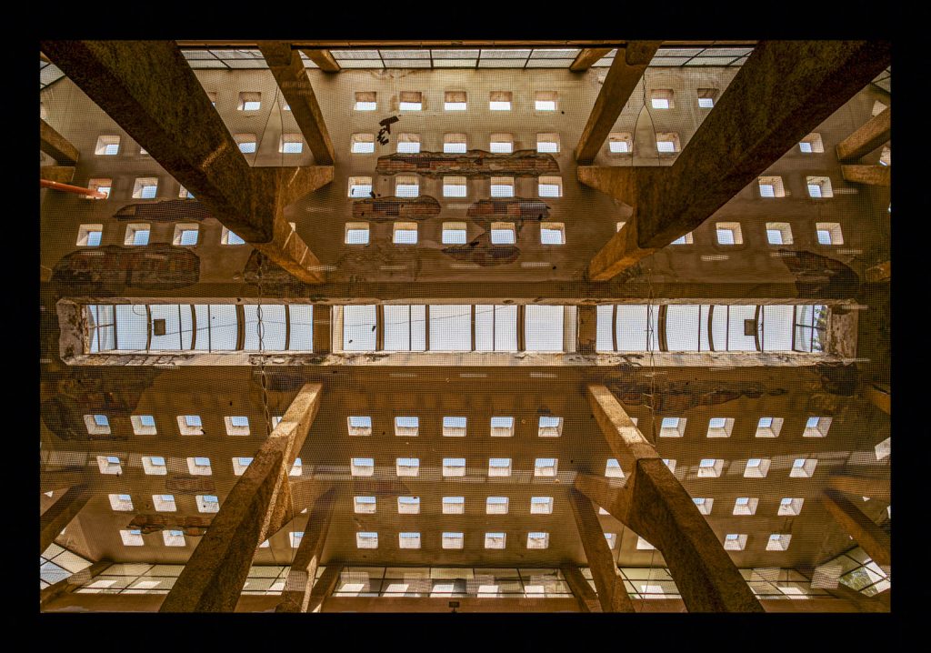 Industrial grid ceiling with skylights, shot from below in symmetry