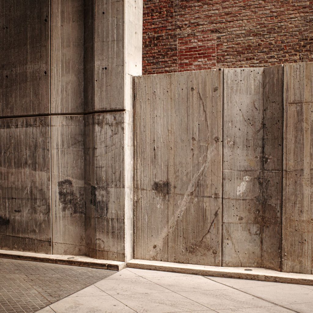 Concrete panels set against an exposed brick wall